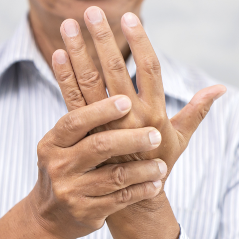 Homme massant sa main endolorie